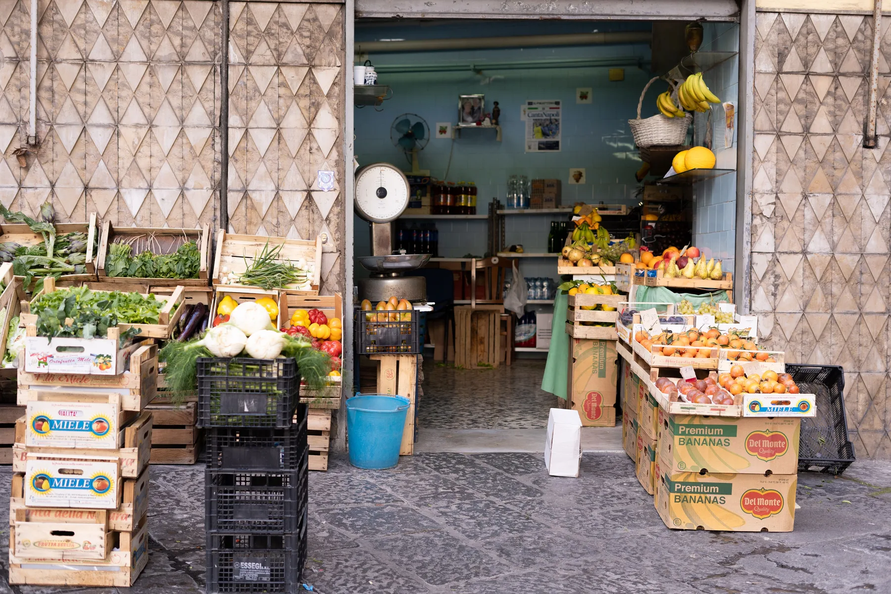 Frutta e ortaggi esposti in cassette presso un mercato professionale